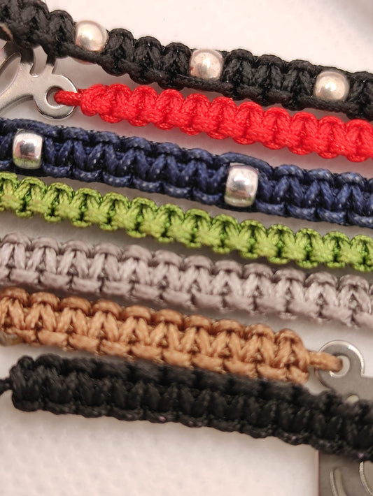 Pulseras artesanales de macramé en diferentes colores y con distintos motivos de zamak